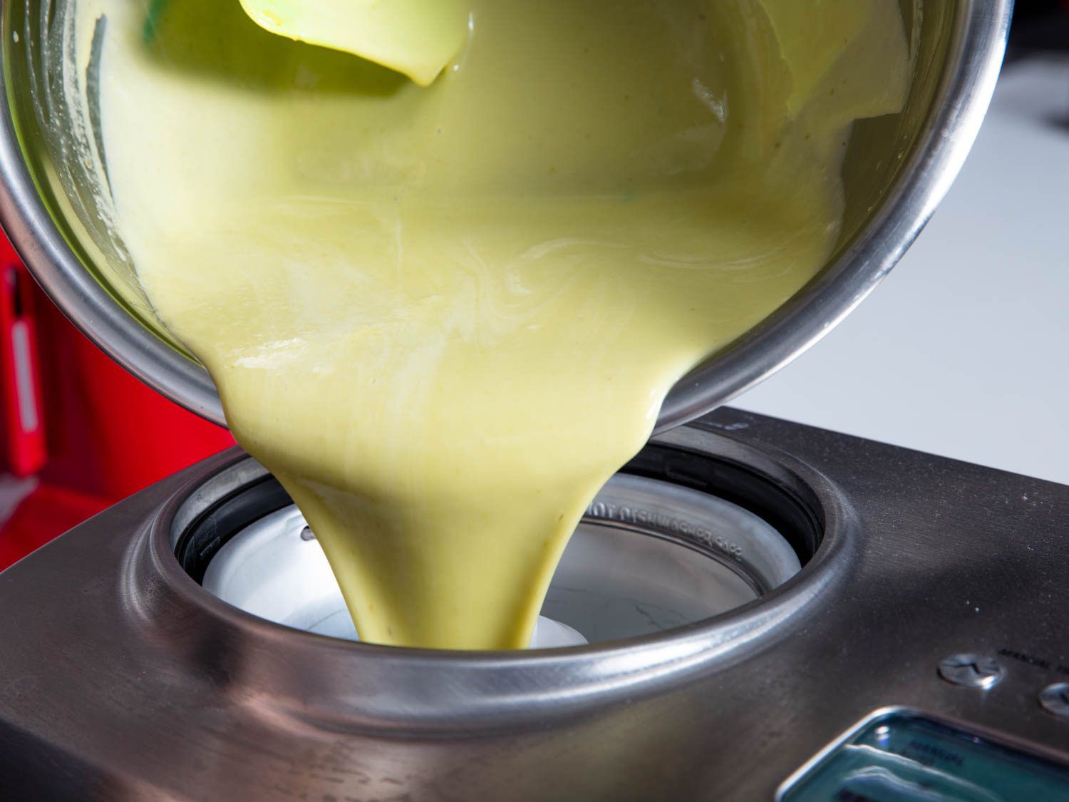 Pouring pistachio ice cream base into an ice cream machine.