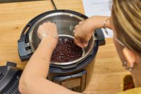A person removes a cake from the Instant Pot Pro 10-in-1 6-Quart Pressure Cooker 