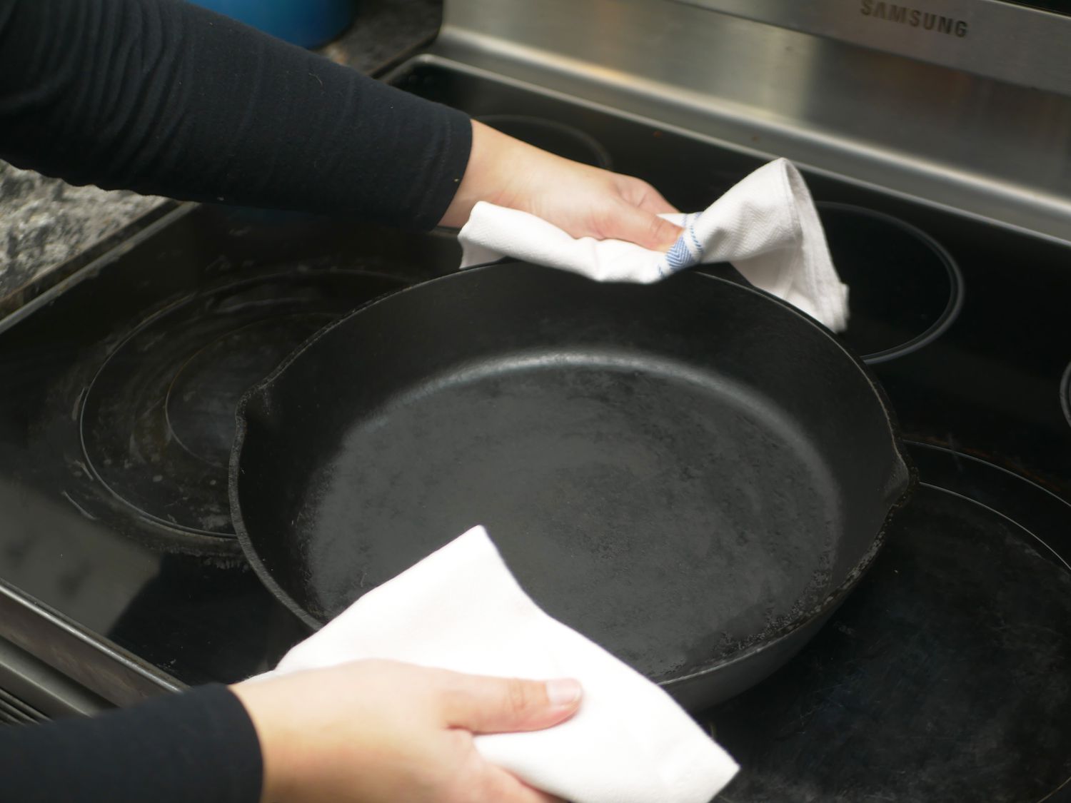 holding the lodge with two kitchen towels 