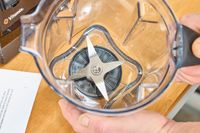 An overhead view of two hands holding an empty Vitamix 7500