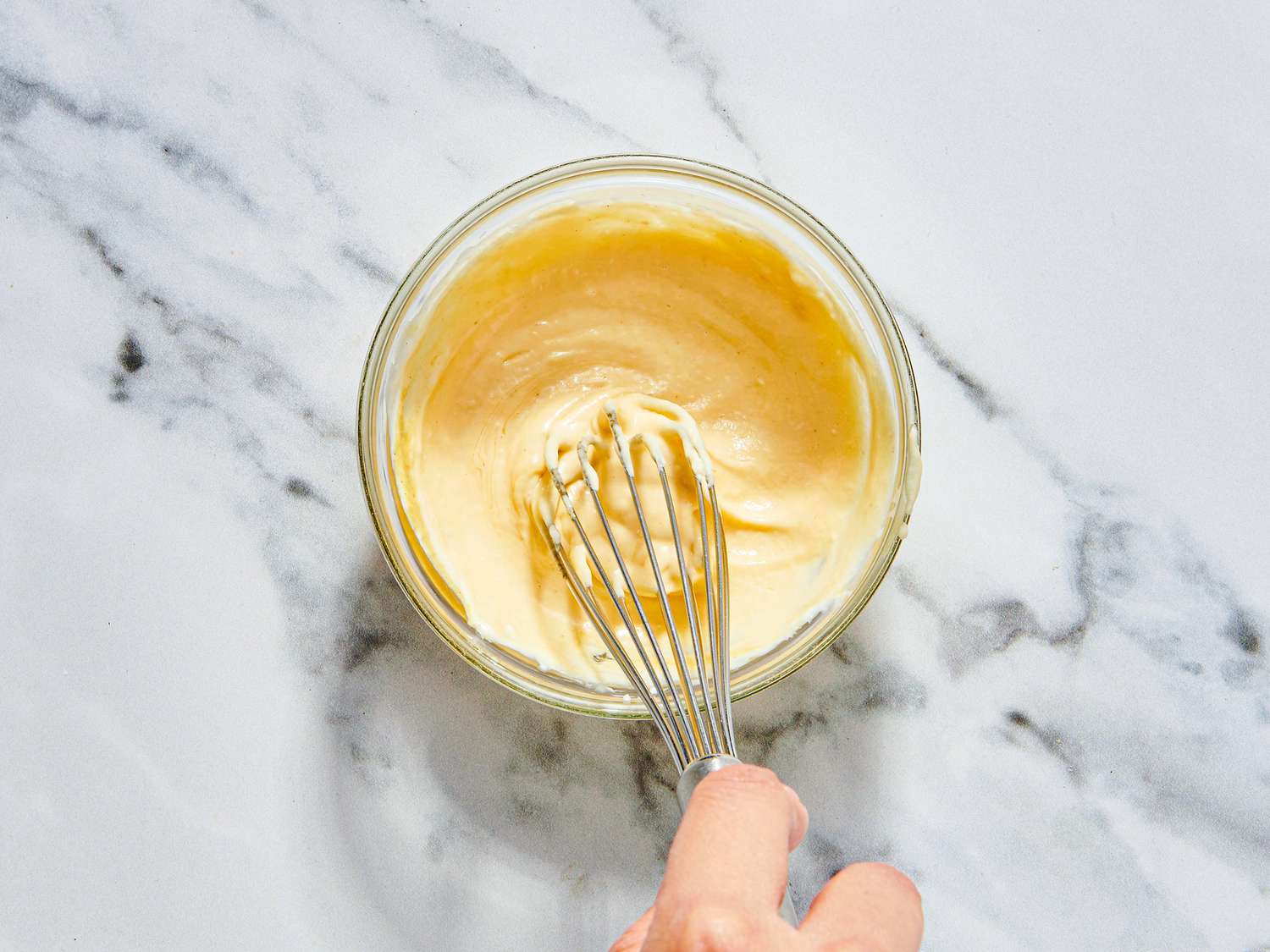 Overhead view of whisking sauce 