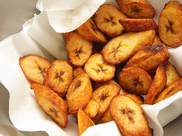 Golden brown fried plantains in a paper towel-lined bowl.