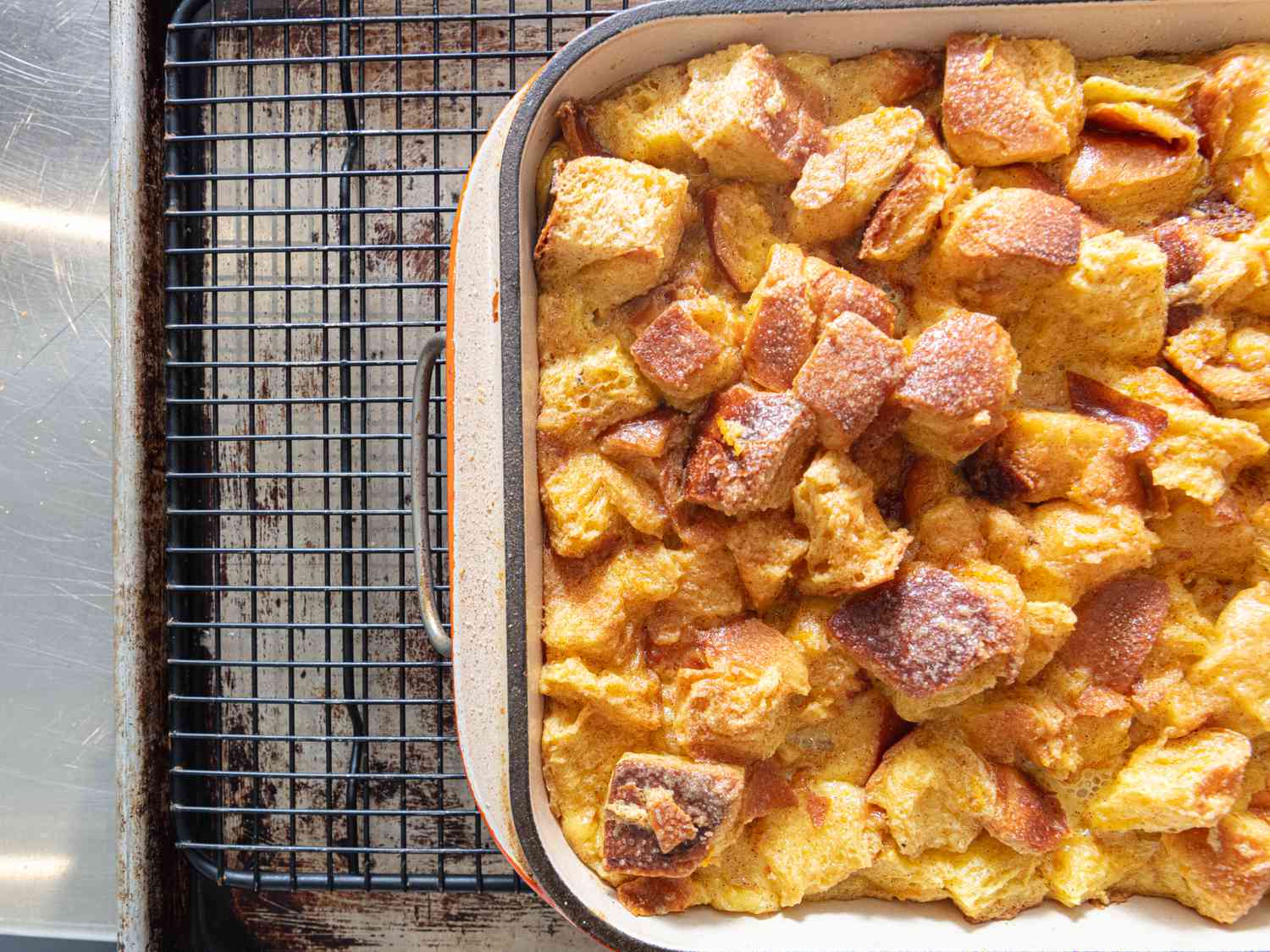 Bread pudding in baking dish, on top of a cooling rack. 