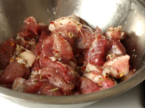 Chunks of pork shoulder tossed in seasoning for sausage