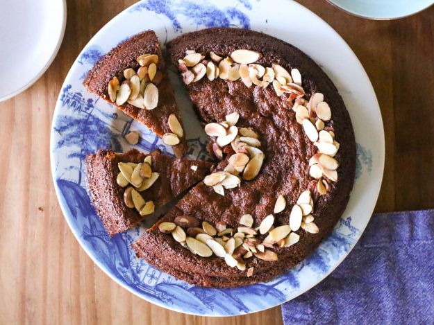 Overhead shot of almond cake on a plate, garnished with slivered almonds