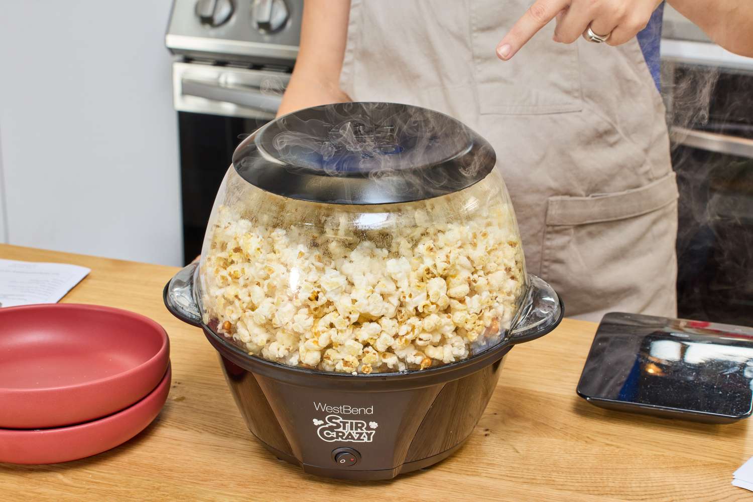Steam is emitted from the West Bend Stir Crazy Electric Hot Oil Popcorn Popper during popping
