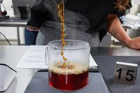Coffee being poured into a glass mug on a scale