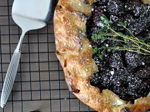 Overhead closeup of a blackberry thyme galette, cooling on a rack.