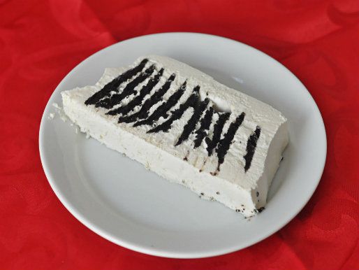 Photo of a slice of chocolate wafer ice box cake, showing the layered cookies within.