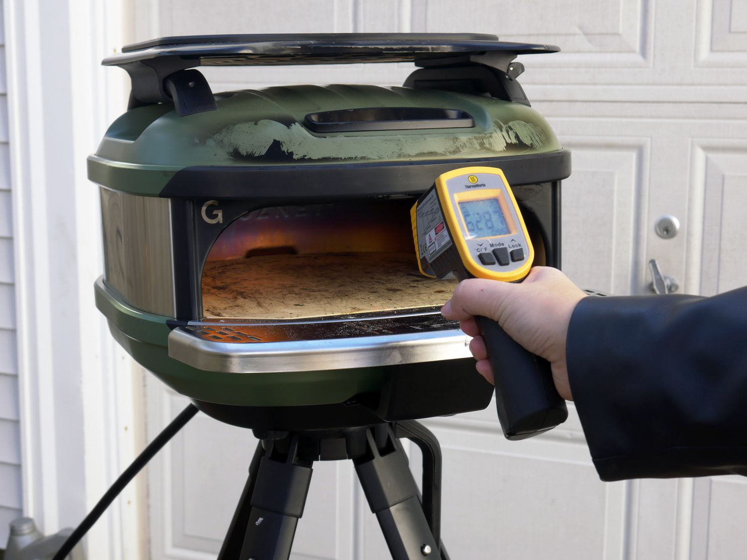 a person using an infarared thermometer to take the temperature of the pizza stone in the Tread