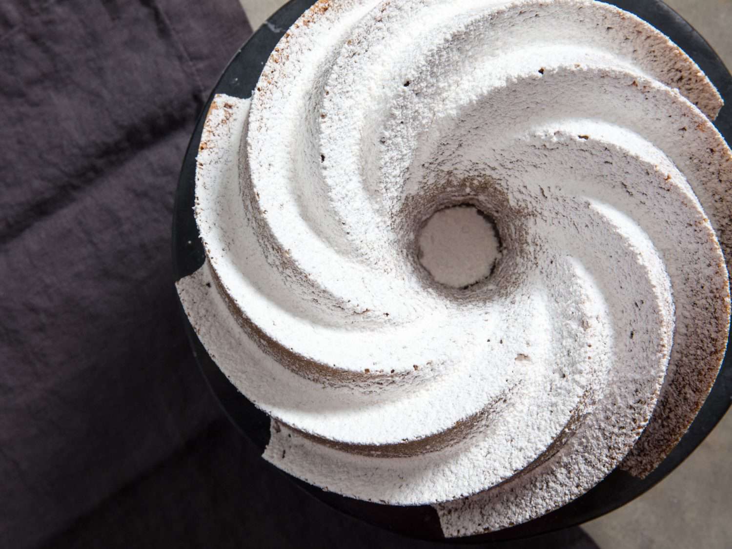 Overhead of a homemade bundt cake dusted with powdered sugar.