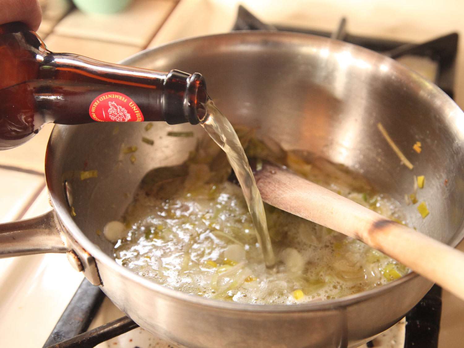 Author adds cider to the saucepan of sweated aromatics.