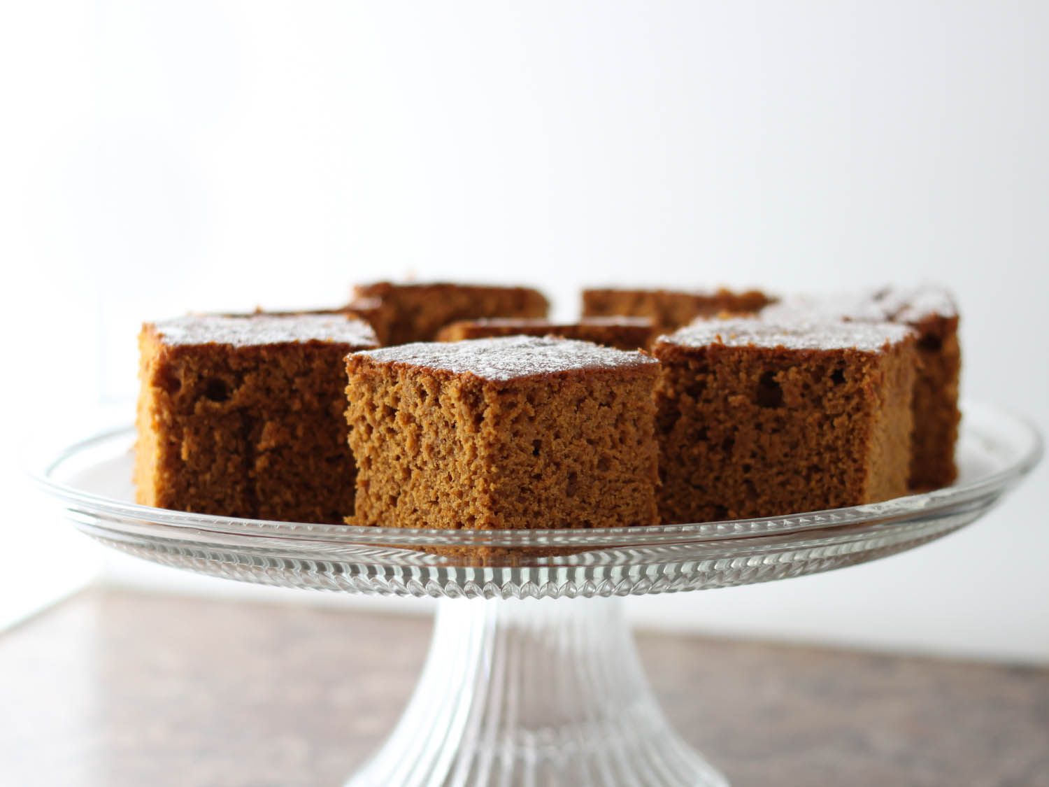 Squares of Gluten-Free Pumpkin Gingerbread on a glass cake stand