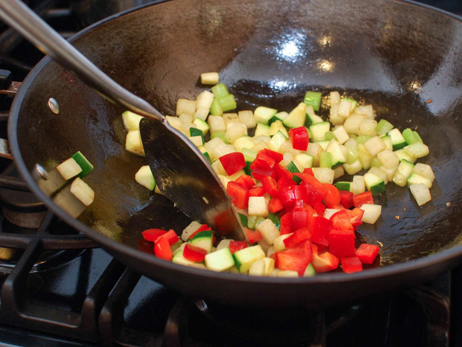 Vegetables for cashew chicken ding in a wok: bell pepper, zucchini, and jicama. 