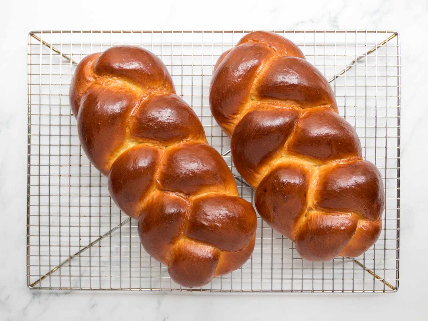 Baked challahs cooling on wire rack