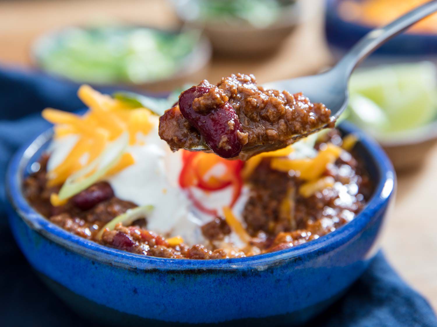 Lifting up a spoonful of pressure cooker ground beef and bean chili