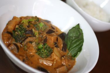Closeup of Massaman Curry with Eggplant and Broccoli, served in smsll white bowl.