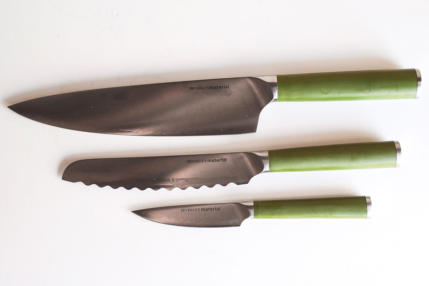 A set of three Material kitchen knives with green handles