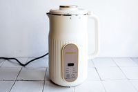 the alfabot nut milk maker on a white tile surface