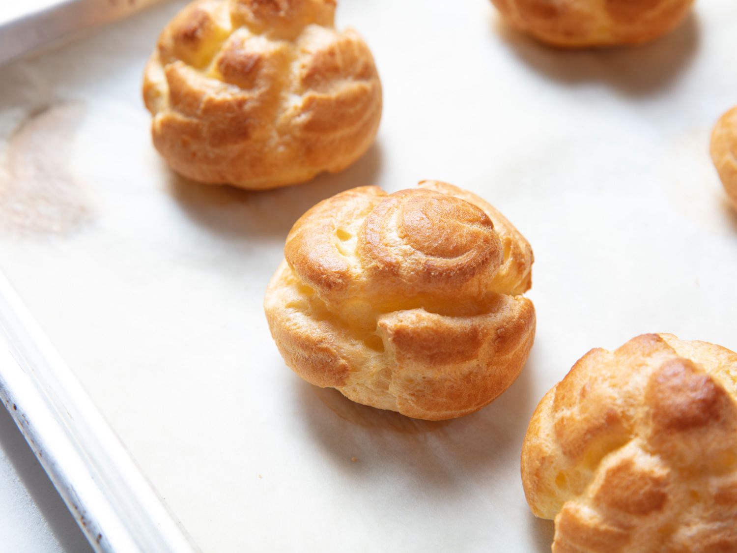 Choux cream puffs that have been cooked on a baking sheet.