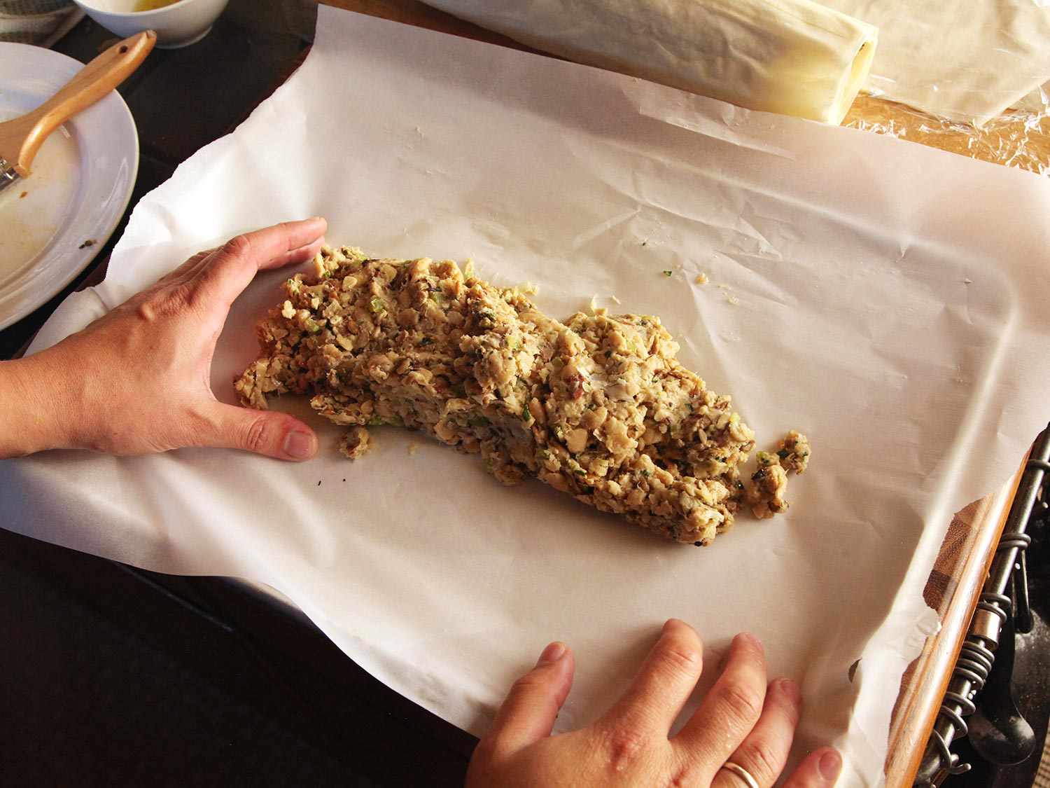 Mounding cashew and bean mixture on parchment paper in baking sheet.
