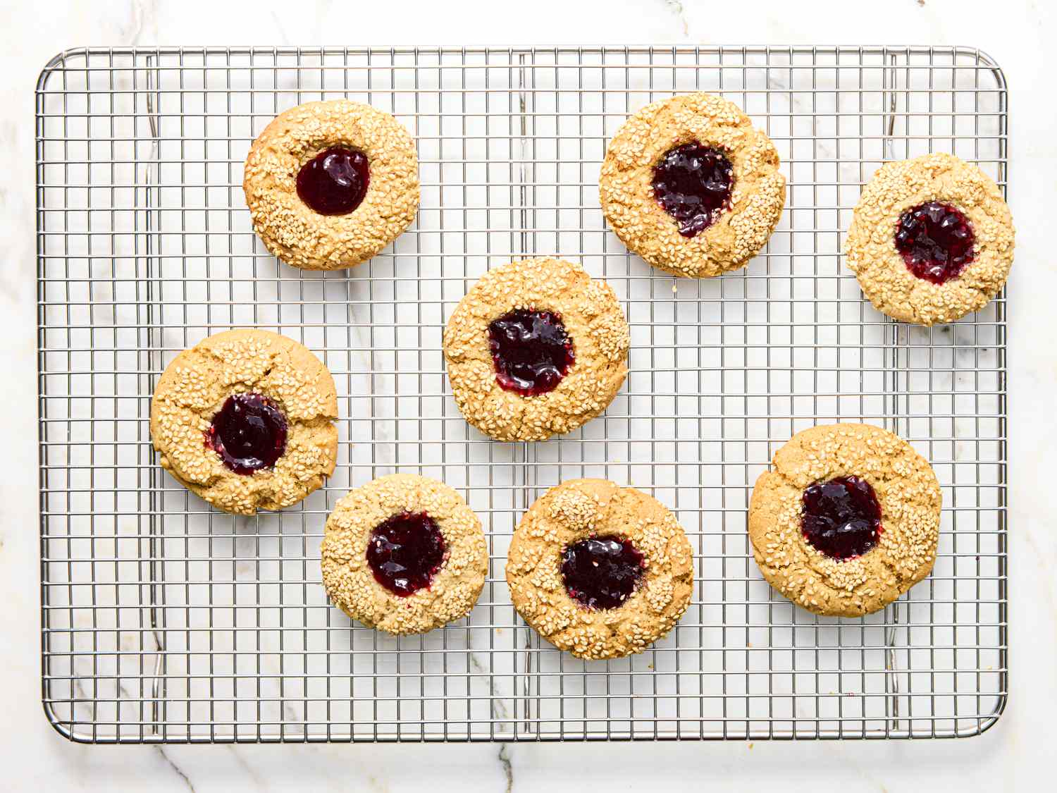 Thumbprint cookies with filling on a cooling rack