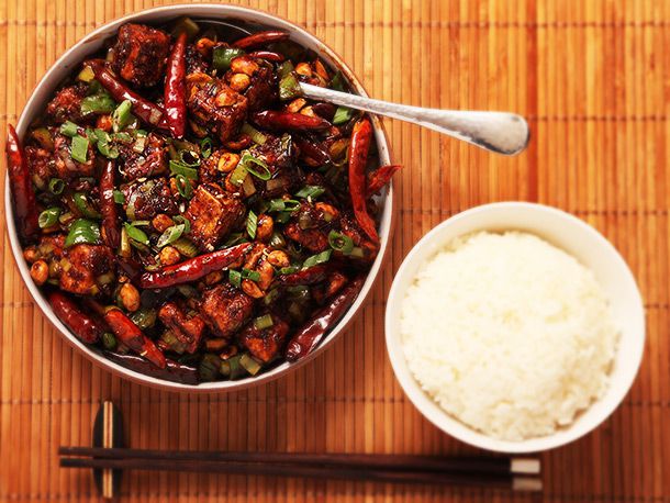 Overhead of crispy vegan kung pao tofu and a bowl of white rice