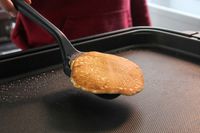 A person using the GIR Premium Silicone Mini Flipper to flip food