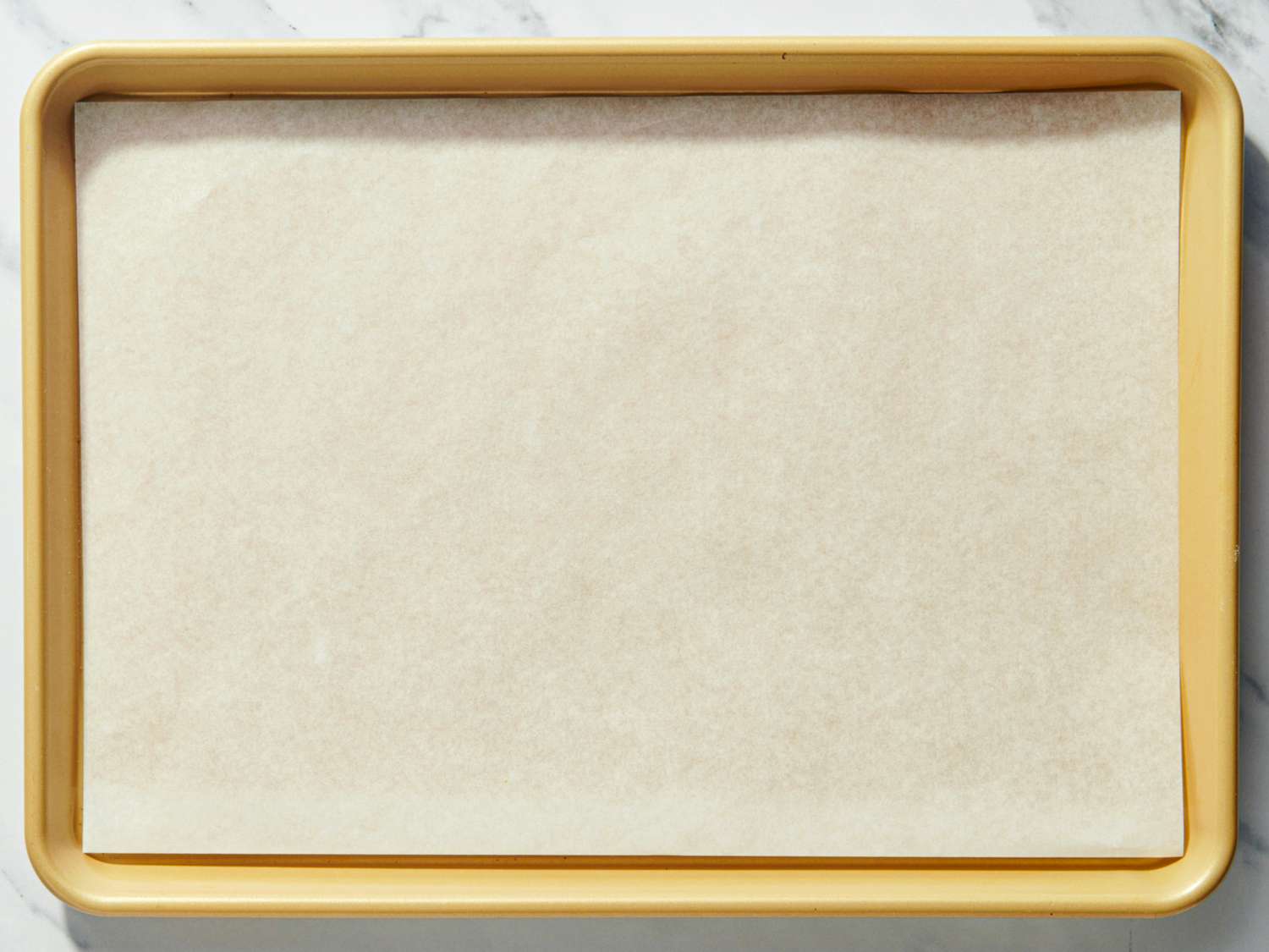 A prepared baking tray lined with parchment paper ready for use