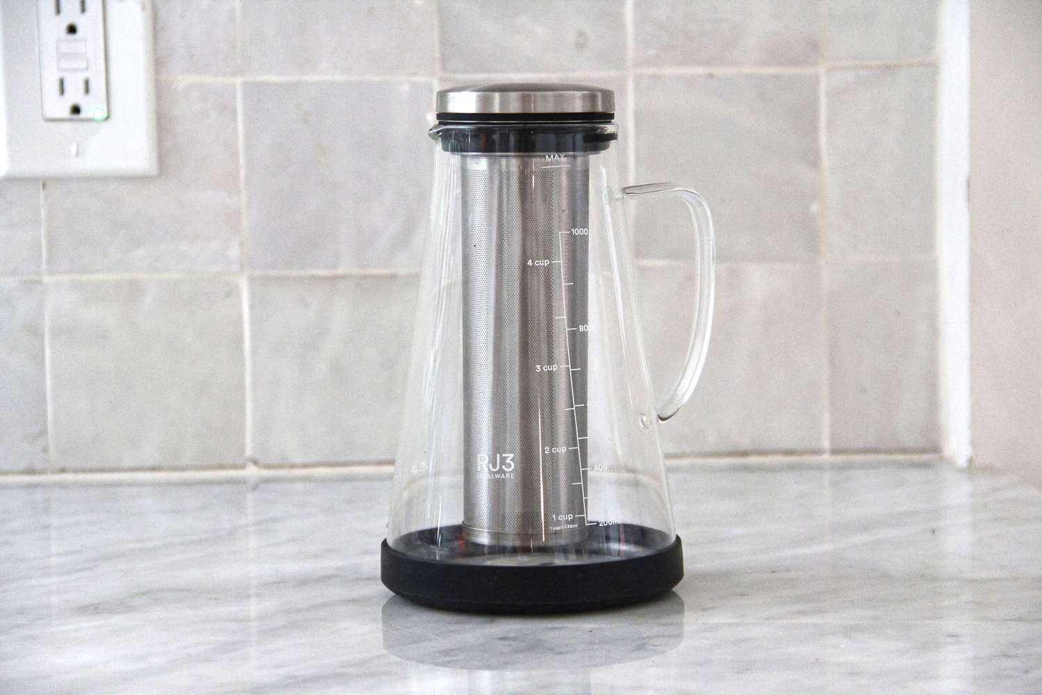 The Ovalware cold brew maker on a marble kitchen countertop.