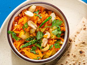 Overhead view of Gajarachi Koshimbir, served in a bowl with flatbreads nearby.