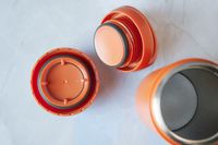 The Kinto travel mug with its lid off and taken apart.