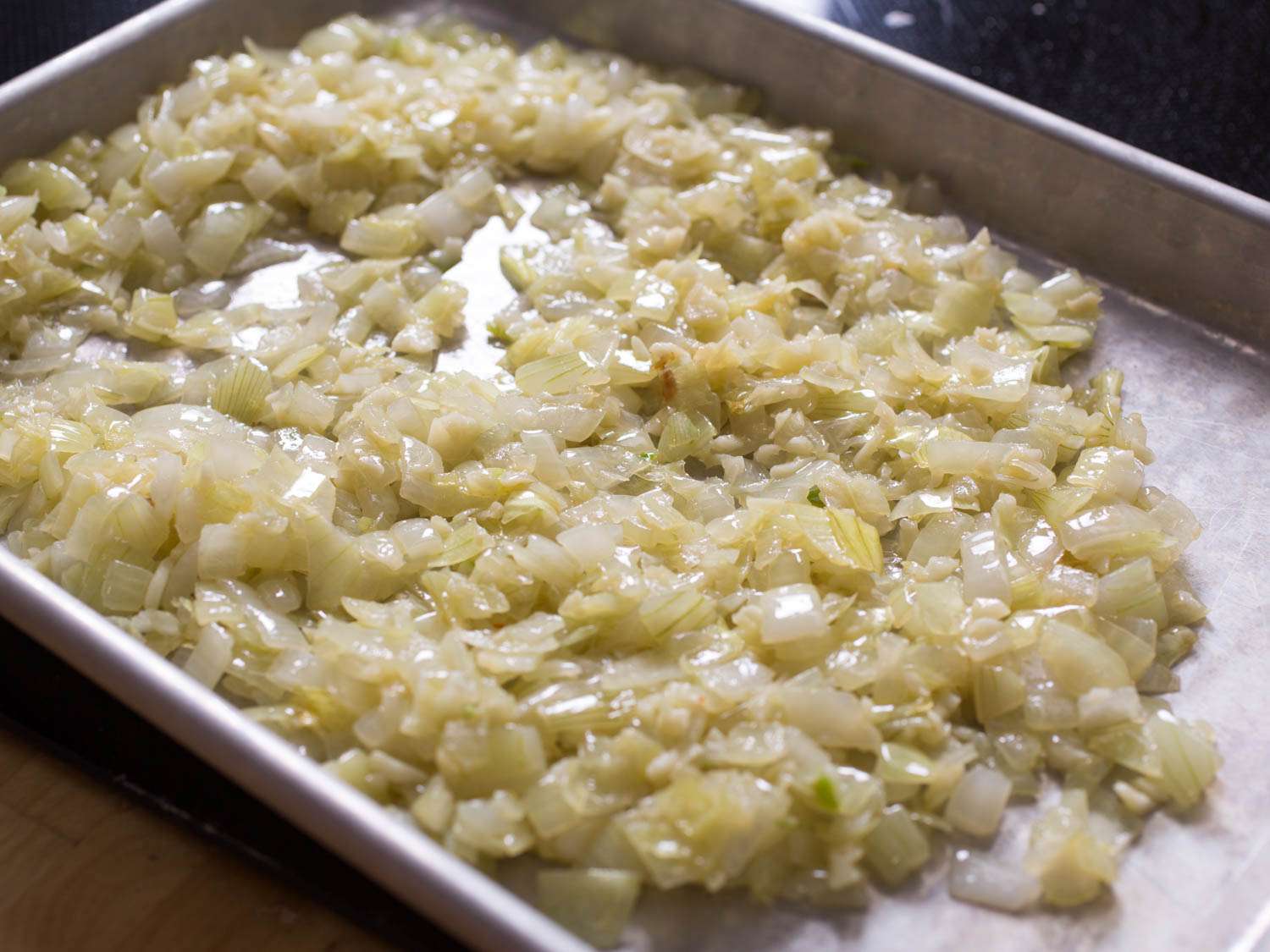 Onion and garlic, cooling on a rimmed baking sheet.