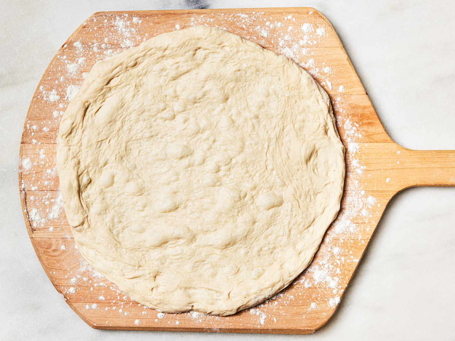 Pizza dough transferred to a pizza peel