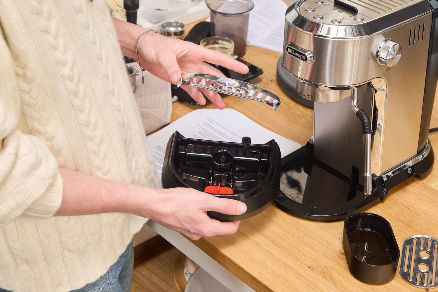 A person assembles the De'Longhi EC900M Dedica Maestro Espresso Machine