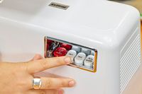 Person pressing buttons of STX International Turboforce Classic 3000 Series Electric Meat Grinder & Sausage Stuffer