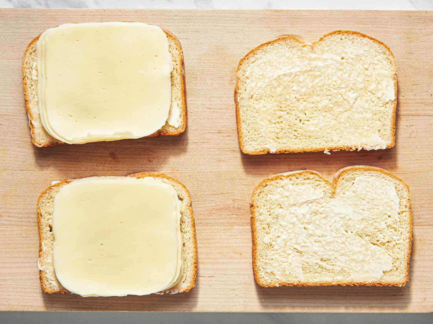 Overhead view of bread with mayo and cheese