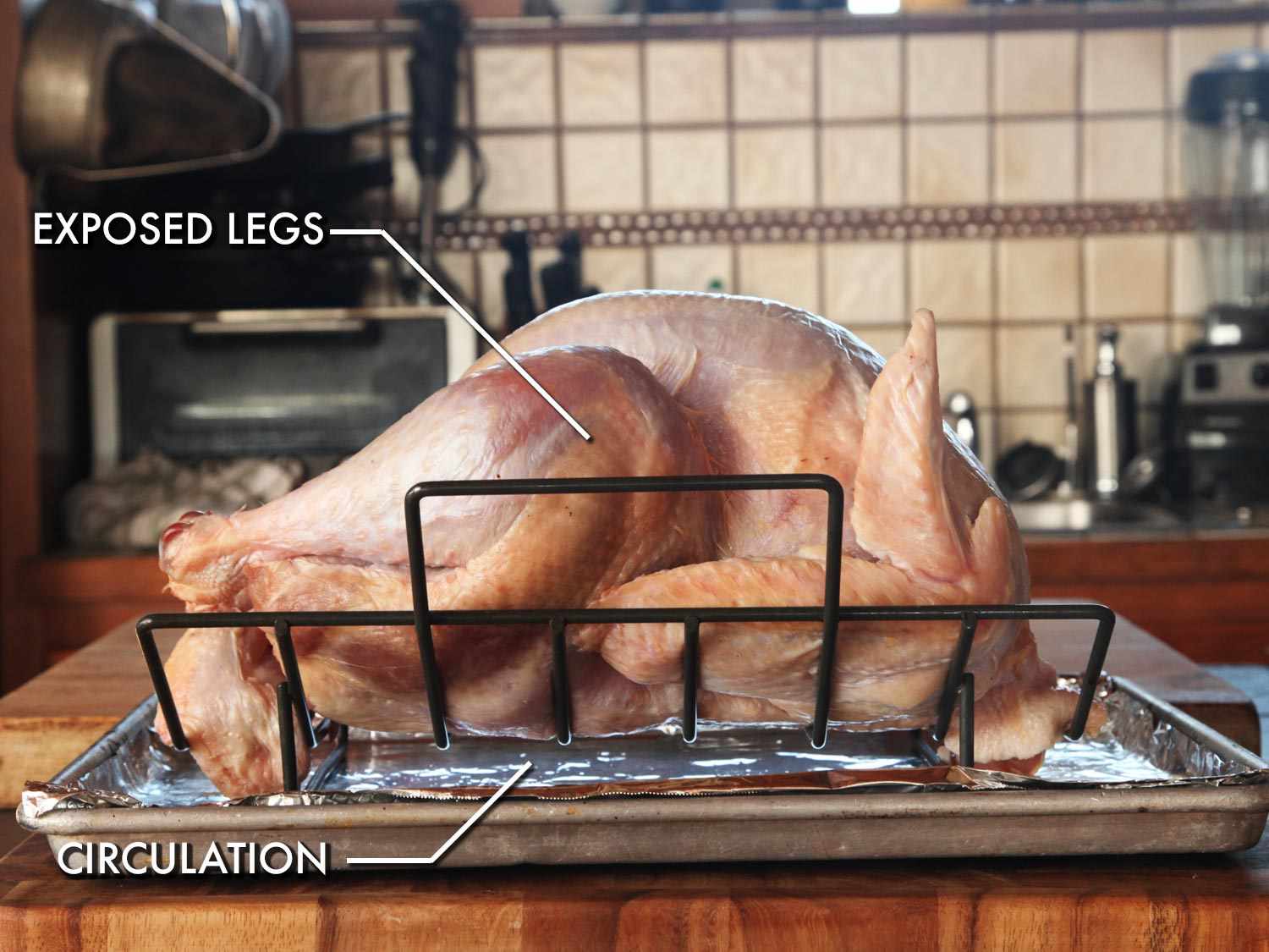 Raw turkey on a rimmed baking sheet fitted with a V-rack.