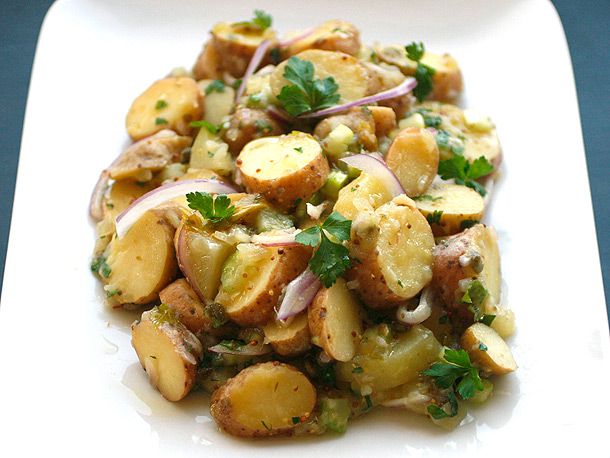 A white plate of Creamy Vegan Fingerling Potato Salad, made with red-skinned potatoes and garnished with parsley leaves
