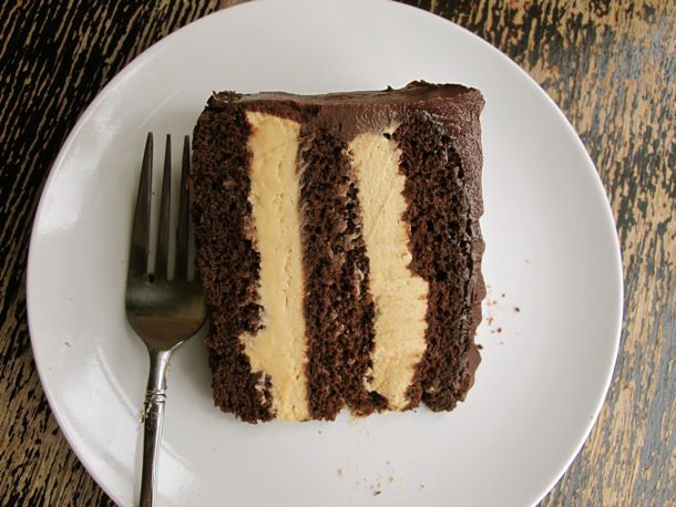 Overhead view of a plated slice of peanut butter chocolate cake. The layers of peanut butter mousse filling are very thick.