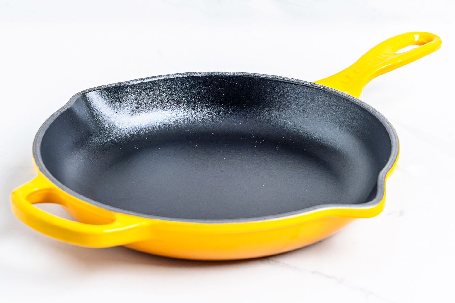A pan from the Le Creuset Signature Enameled Cast Iron Cookware Set on a white background