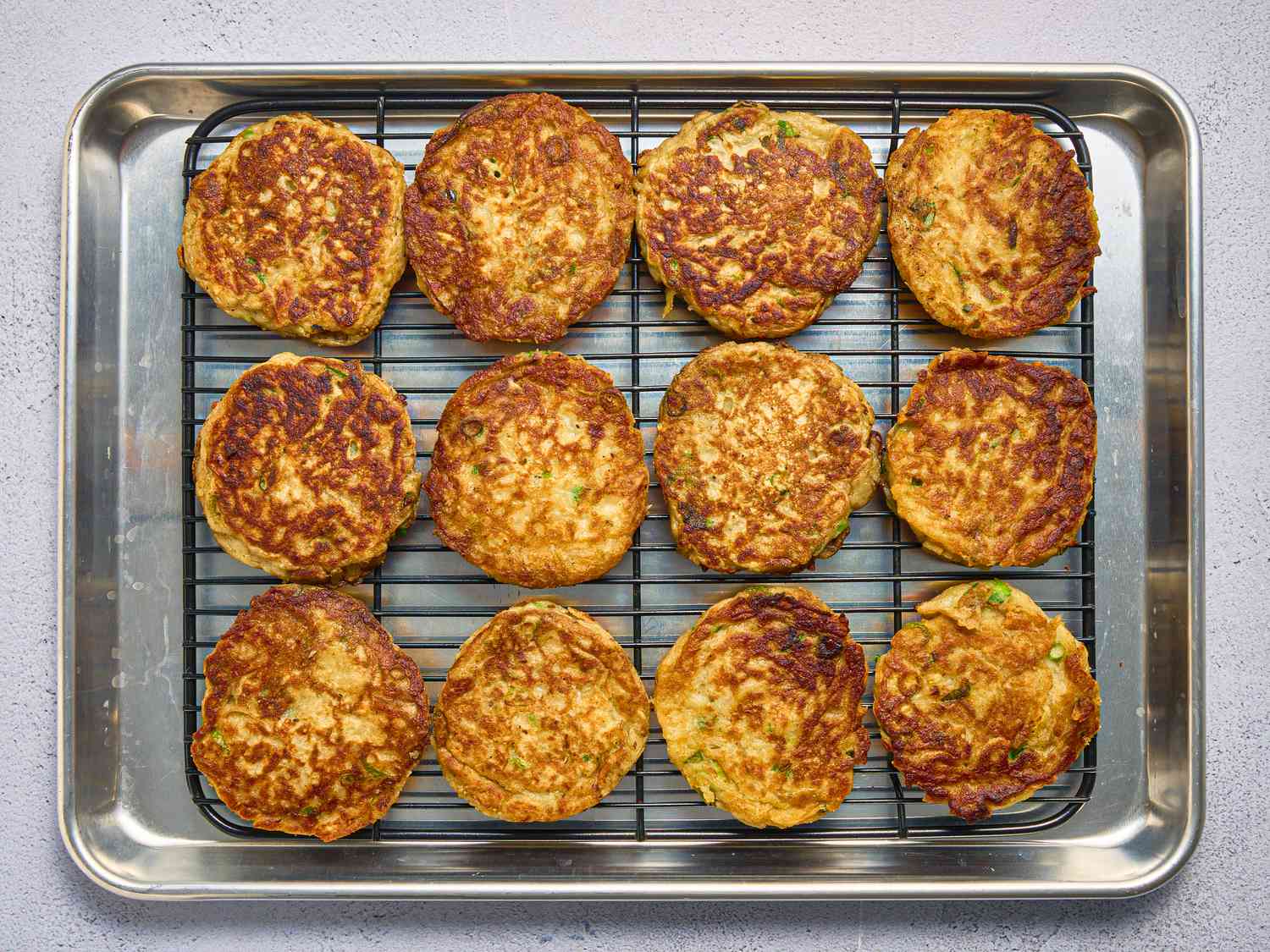 cooked boxty pancakes on a cooling rack on a sheetpan 