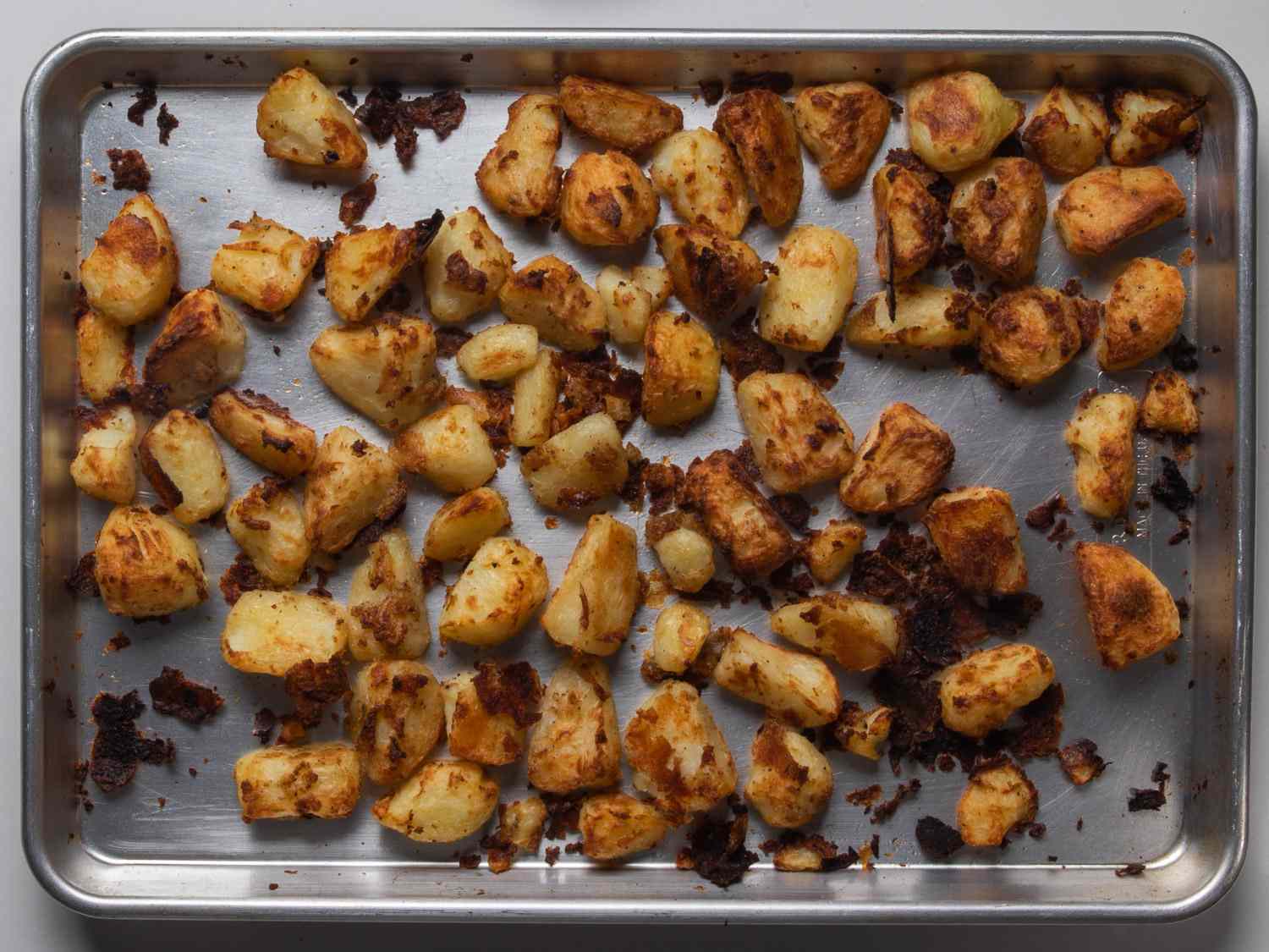The crispy roast potatoes on a metal baking sheet.
