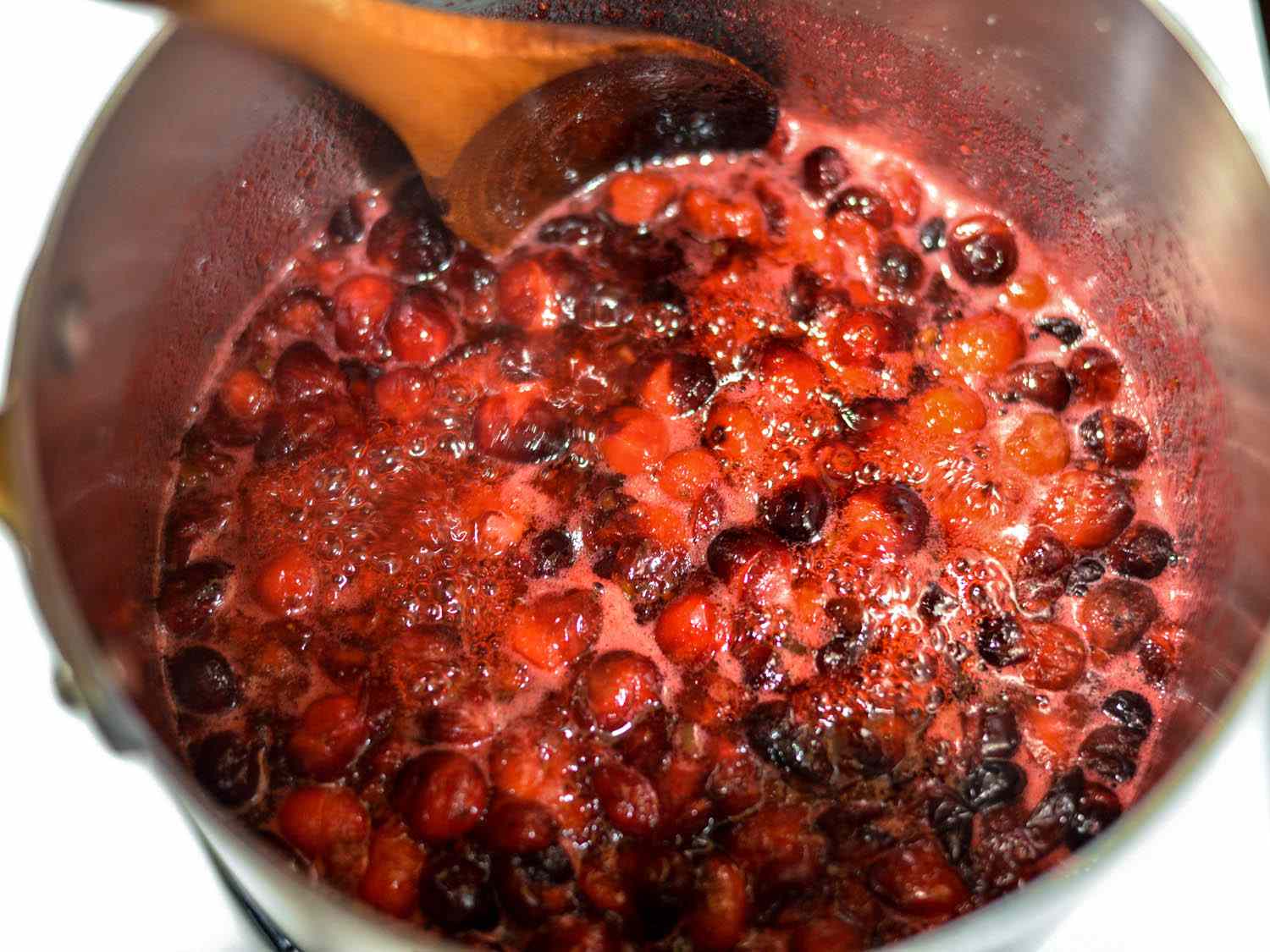 Cranberry sauce bubbling in a saucepan. 