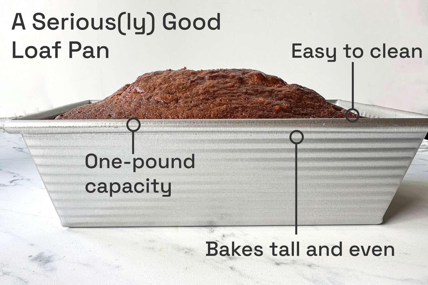 A loaf pan with a baked loaf labeled with features such as onepound capacity bakes tall and even and easy to clean