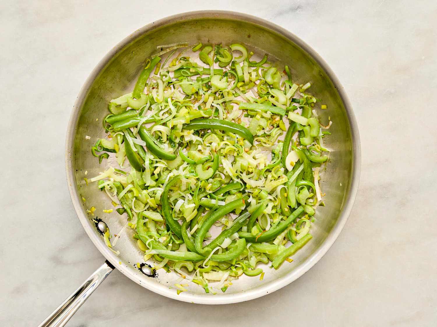 Celery and leek sauteing in skillet 