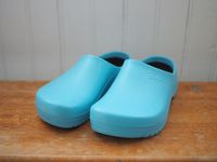 A pair of blue Birkenstock clogs on a wooden surface.
