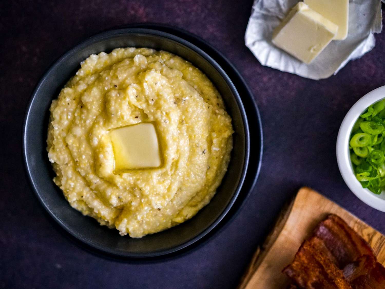 Overhead view of a bowl of grits topped with a pat of butter