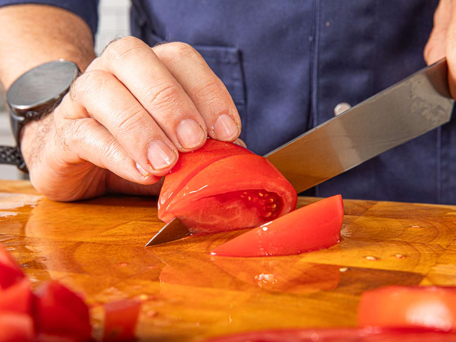 Side view of cutting tomatoes into wedges
