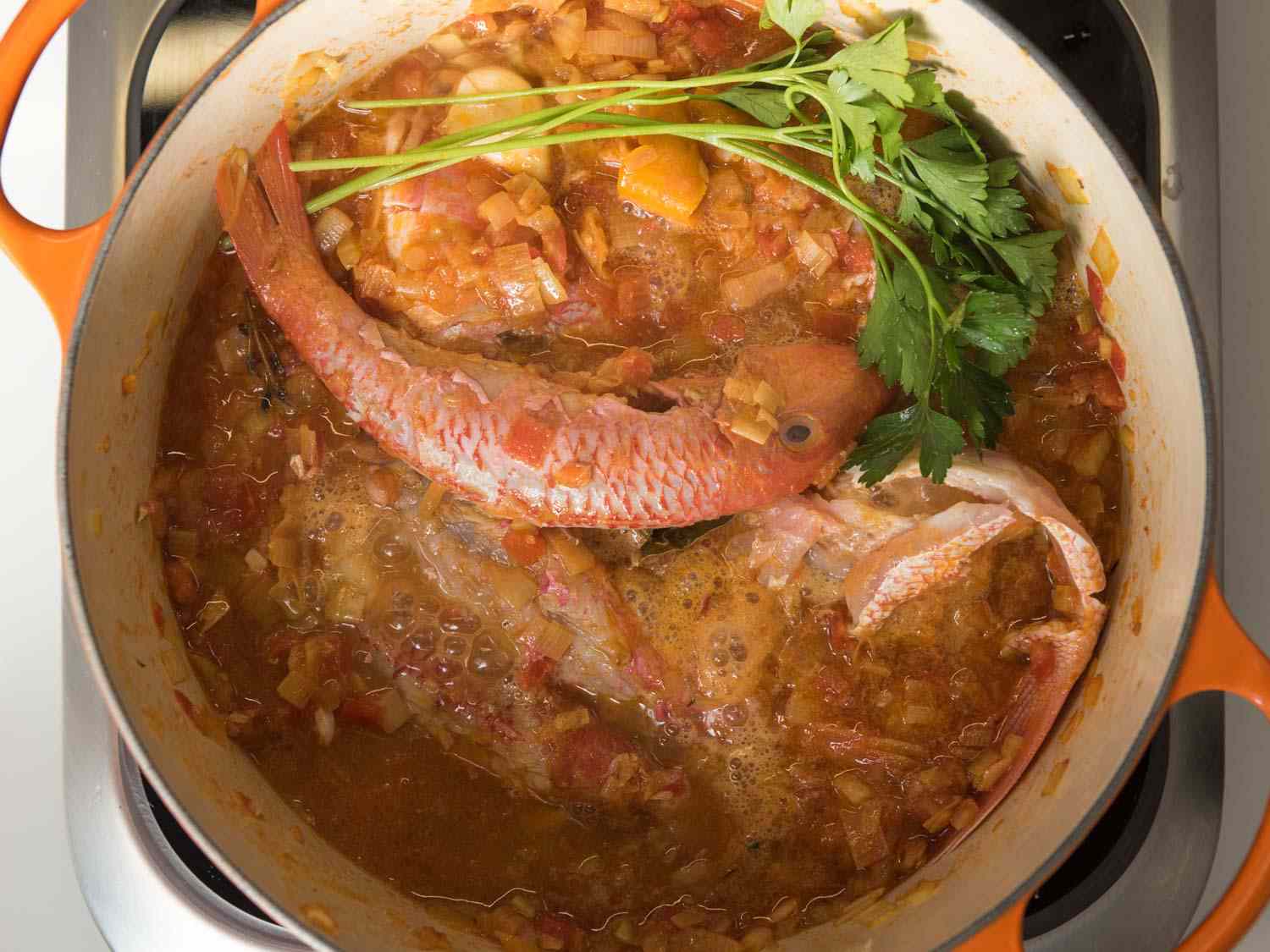 Fish bones and parsley added to the bouillabaisse base. 